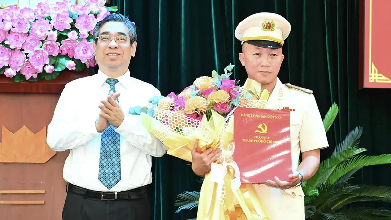 Đồng chí Nguyễn Phước Lộc, Phó Bí thư Thành ủy, Chủ tịch Uỷ ban MTTQ Việt Nam TPHCM trao quyết định cho Thượng tá Phan Thanh Bình. Ảnh: VIỆT DŨNG 