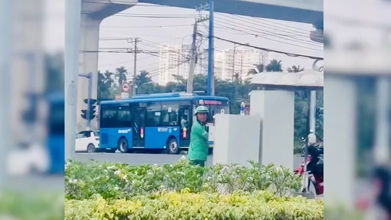 Hình ảnh người đàn ông mặc đồ GrabBike chỉnh tín hiệu đèn giao thông ở TP Thủ Đức