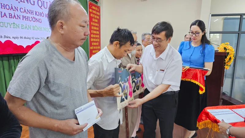 Nhà báo Trương Đức Nghĩa, Phó Tổng Biên tập Báo Sài Gòn Giải Phóng trao tặng quà đến các hộ dân có hoàn cảnh khó khăn