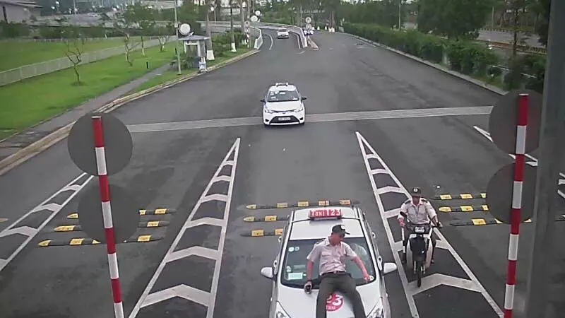 Taxi đâm hất nhân viên hàng không lên nắp capo (ảnh cắt từ clip)