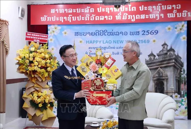 Phó Bí thư Thành ủy TPHCM Đặng Minh Thông tặng quà chúc Tết Tổng lãnh sự Lào tại TPHCM Phonesy Bounmixay, nhân dịp Tết cổ truyền của Lào. Ảnh: TTXVN