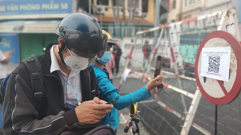 Người dân khai báo tại trạm kiểm soát trên đường Nguyễn Bỉnh Khiêm. Ảnh: DŨNG PHƯƠNG