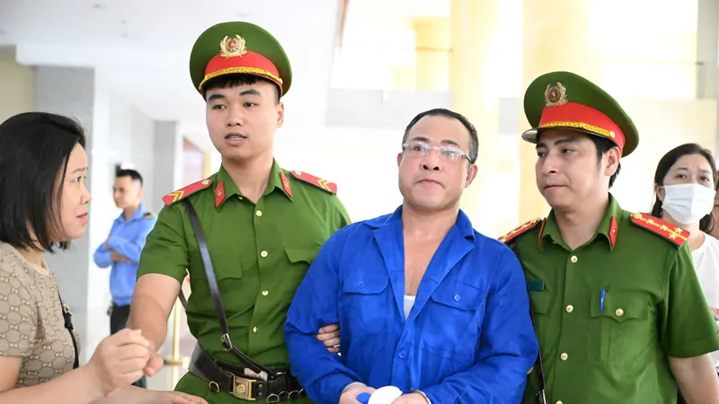Bị cáo Nghiêm Quang Minh được dẫn giải vào phòng xử. Ảnh: ĐỖ TRUNG