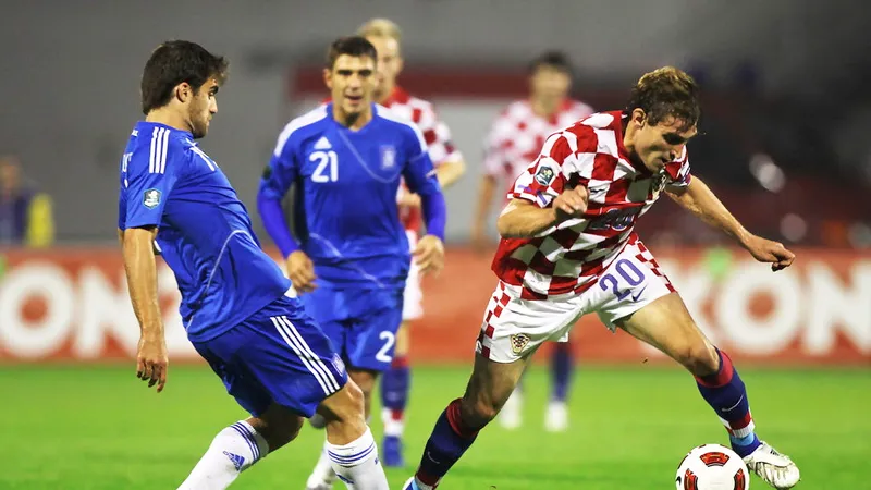 Nikica Jelavic (phải, Croatia) vượt qua Sokratis Papadopoulos (Hy Lạp). Ảnh: Getty Images.