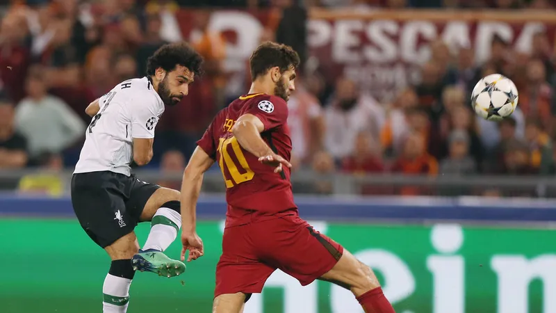 Mohamed Salah (trái, Liverpool) sút bóng trước hậu vệ Roma
