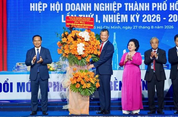 胡志明市人委会主席阮文得向胡志明市企业联合会执委会赠花。图：黄雄