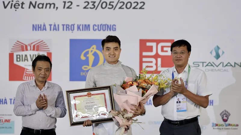 Thứ trưởng Bộ VH-TT-DL Hoàng Đạo Cương và Tổng cục trưởng Tổng cục TDTT Đặng Hà Việt trao bằng khen và hoa cho kiếm thủ Vũ Thành An. Ảnh: DŨNG PHƯƠNG