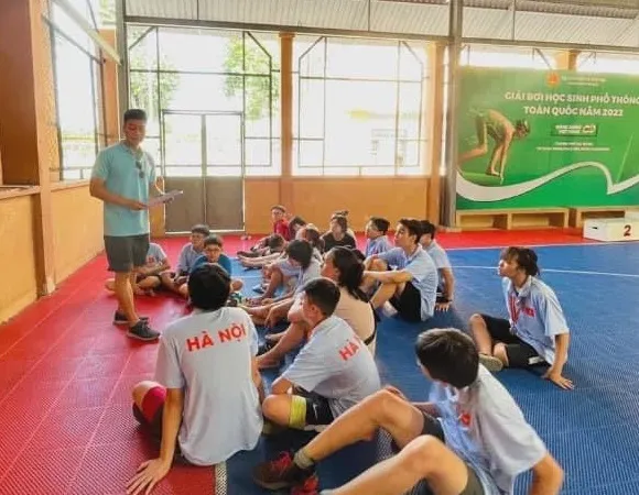 HLV Đỗ Huy Long trao đổi cùng các học viên nhí của mình tại giải bơi học sinh phổ thông toàn quốc 2022 vừa qua. Ảnh: FTSM