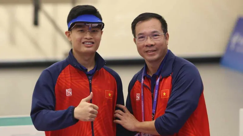 Phạm Quang Huy và HLV Hoàng Xuân Vinh sau khi giành HCV tại ASIAD 19. Ảnh: LƯỢNG LƯỢNG