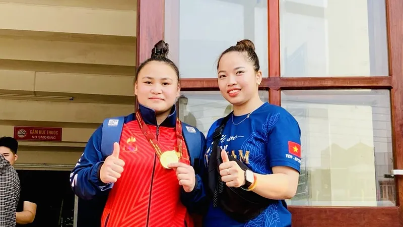 HLV Lò Thị Hoàng và học trò của mình giành được tấm HCV đầu tiên cho cử tạ Sơn Lan. Ảnh: Q.THẮNG