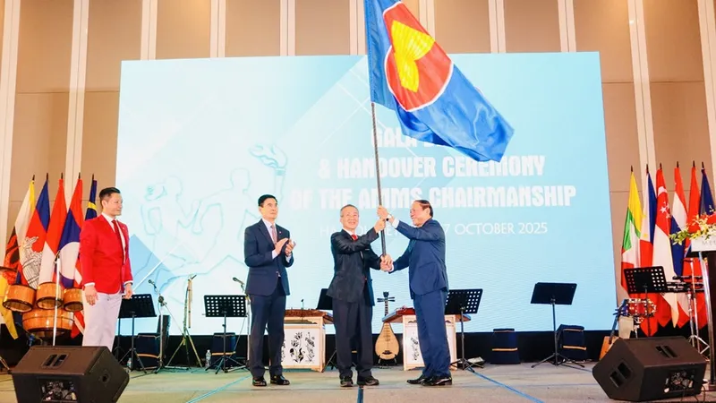 Bộ trưởng Nguyễn Văn Hùng trao cờ ASEAN cho quốc gia chủ nhà AMMS-9 là Campuchia. Ảnh: LƯỢNG LƯỢNG