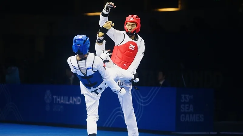 Võ sĩ Nguyễn Hồng Trọng (đỏ) đã có tấm HCV tại SEA Games 33-2025. Ảnh: DŨNG PHƯƠNG