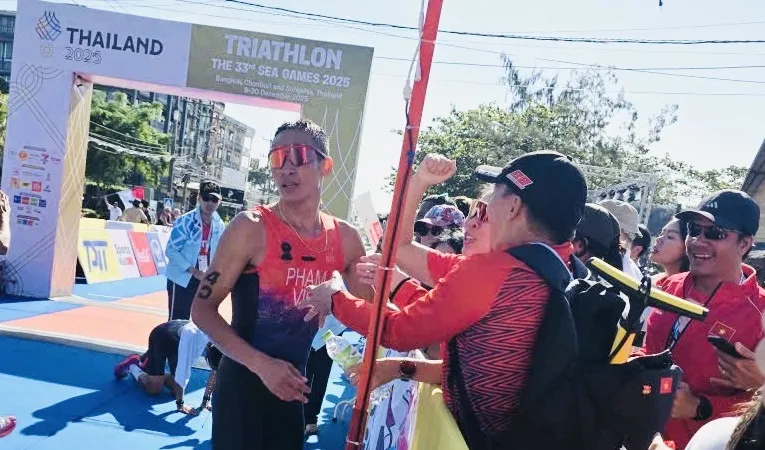 Phạm Tiến Sản được Ban huấn luyện đội tuyển triathlon Việt Nam chúc mừng khi hoàn thành chiến thắng giành HCV. Ảnh: MINH MINH