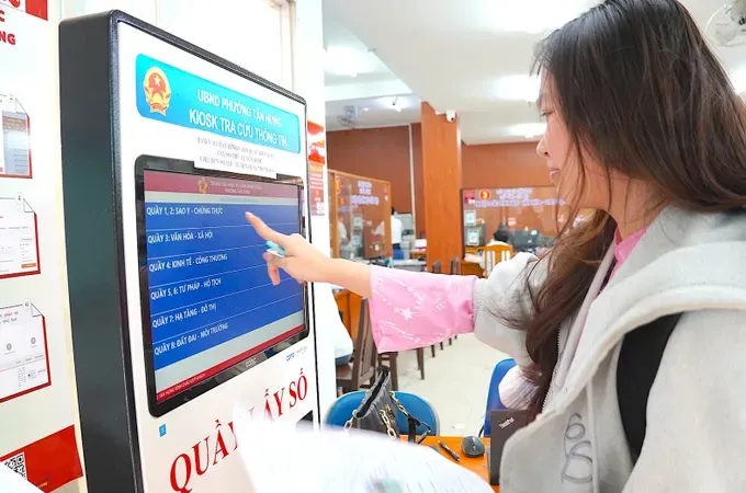 Citizen are interacting with a touchscreen to receive guidance from a virtual assistant at the Tan Hung Ward Public Administration Service Center 