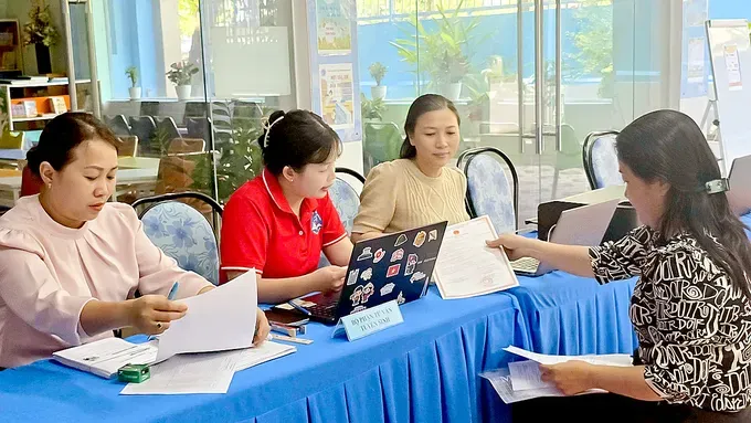 A parent is submitting a first-grade enrollment dossier at Tran Khanh Du Primary School in Tan Dinh Ward (Photo: SGGP)