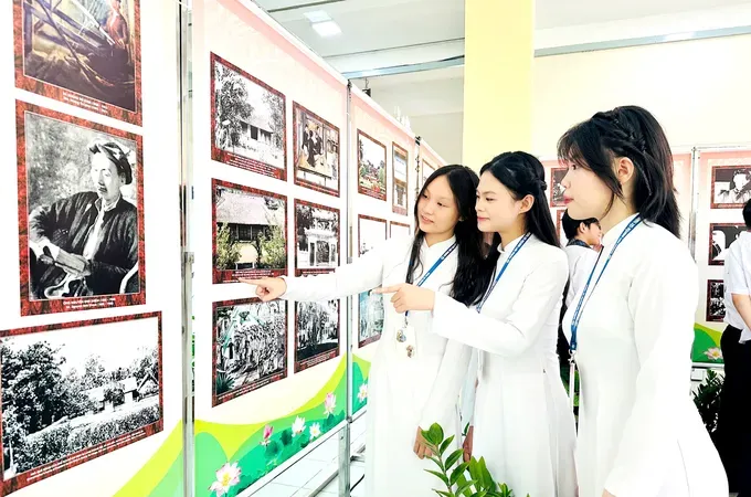 Students of Nguyen Tat Thanh High School in Binh Phu Ward are carefully examining documentary photos depicting late President Ho Chi Minh’s life at the Ho Chi Minh Cultural Space (Photo: SGGP)