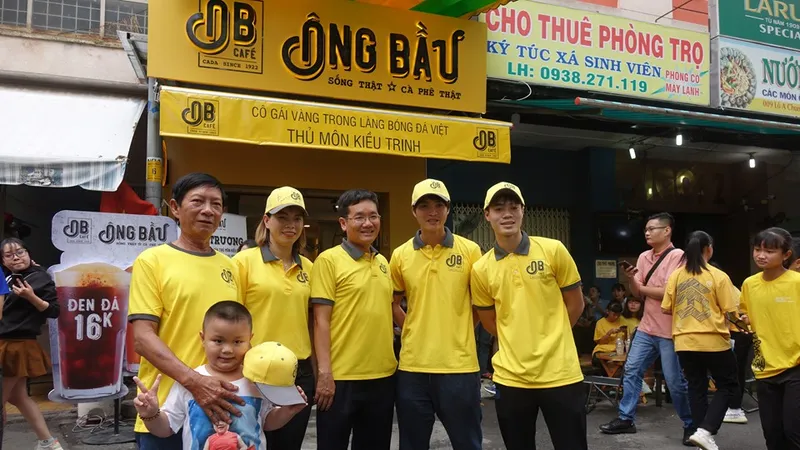 Ông Trần Thanh Hải, Chủ tịch Công ty NutiFood, cùng hai cầu thủ Văn Toàn, Tuấn Anh chụp ảnh lưu niệm cùng cô chủ Kiều Trinh. Ảnh: Anh Trần