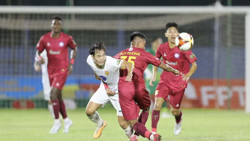 Văn Toàn nỗ lực thoát qua sự kèm cặp của hậu vệ Khánh Hòa. Ảnh: DŨNG PHƯƠNG
