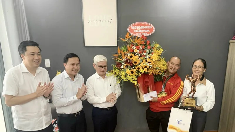 Ông Nguyễn Văn Lợi - Bí thư tỉnh ủy Bình Dương và đoàn lãnh đạo tỉnh Bình Dương tặng hoa và quà chúc mừng VĐV Hồ Huy Bình. 