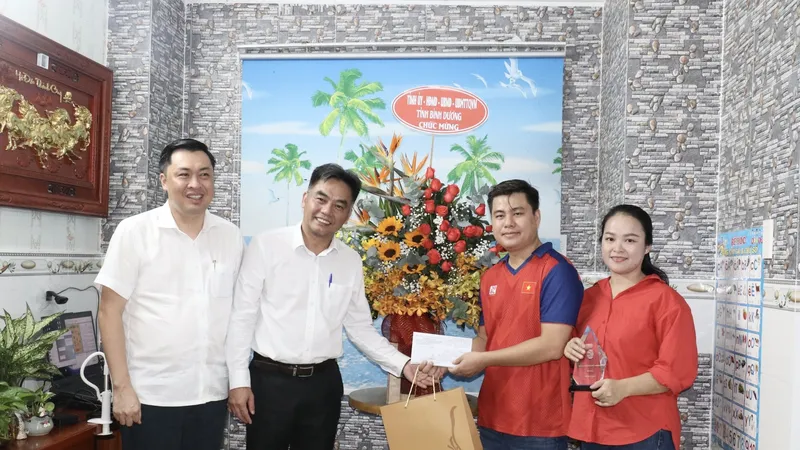 Ông Nguyễn Lộc Hà - Phó Chủ tịch UBND tỉnh và ông Cao Văn Chóng - Phó Giám đốc Sở VH-TT&DL tỉnh tặng hoa và quà chúc mừng VĐV Lại Lý Huynh và chị Nguyễn Thị Kim Hương, vợ của VĐV Lại Lý Huynh tại nhà riêng