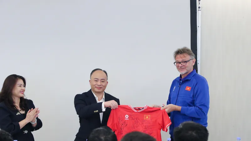 HLV trưởng Philippe Troussier thay mặt đội tuyển tặng Đại sứ quán Việt Nam tại Qatar áo thi đấu có chữ ký của các thành viên đội tuyển. 