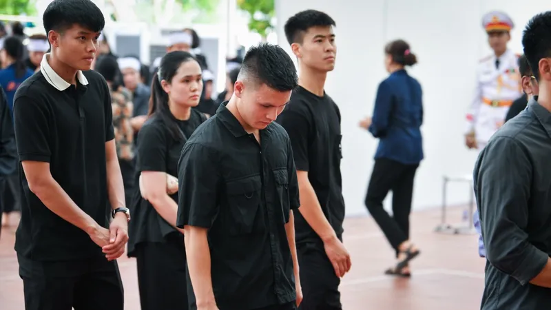 Các tuyển thủ quốc gia Quang Hải, Duy Mạnh và Văn Tùng cùng rất đông người dân đã xếp hàng vào viếng Tổng Bí thư Nguyễn Phú Trọng tại xã Đông Hội, huyện Đông Anh, thành phố Hà Nội. Ảnh: VOV
