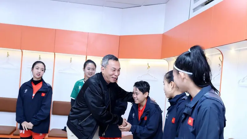 Ông Trần Quốc Tuấn bắt tay động viên Ngân Thị Vạn Sự cùng các tuyển thủ nữ Việt Nam tại buổi gặp.