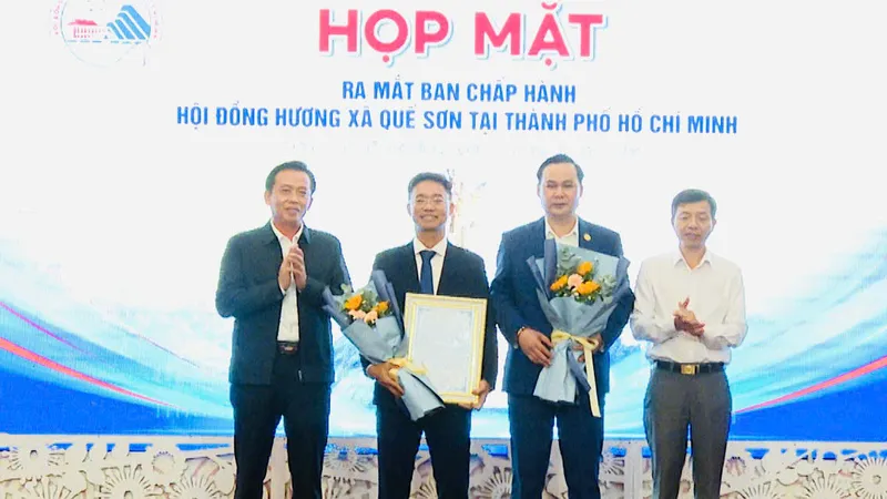 Ông Ngô Công Quang và ông Hà Văn Tự (giữa) nhận hoa chúc mừng từ lãnh đạo địa phương,