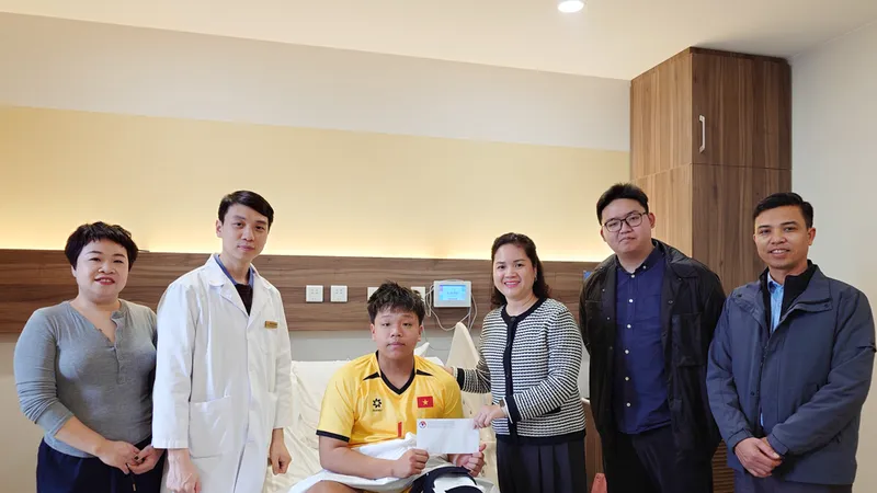 Bà Nguyễn Thanh Hà (thứ 3 từ trái sang) thay mặt lãnh đạo VFF đến thăm cầu thủ Đoàn Tuấn Phong tại bệnh viện sau khi phẫu thuật thành công.