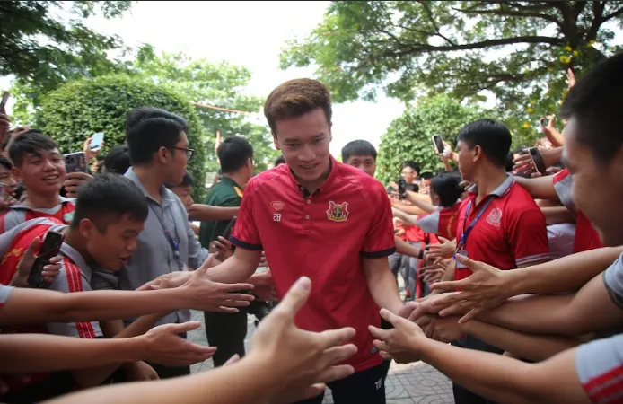 Các bạn trẻ chào đón Hoàng Đức cùng những thành viên của CLB Ninh Bình từ sân trường. Ảnh: DŨNG PHƯƠNG