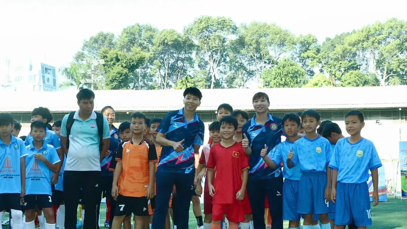 Các nữ tuyển thủ quốc gia Kim Thanh, Thùy Trang chụp hình lưu niệm cùng các cầu thủ nhí. Ảnh: HTV