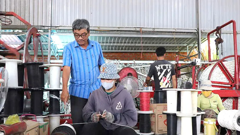 Ông Hùng tận tay hướng dẫn người lao động tại cơ sở về việc đánh dây thừng.