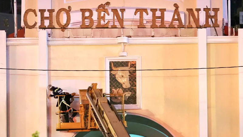 Công nhân thi công sơn, chỉnh trang mặt tiền chợ Bến Thành trong đêm, tranh thủ thời gian hoàn thiện các hạng mục trước năm mới. (ẢNH: HOÀNG HÙNG)