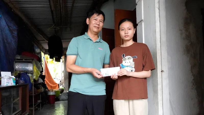 Đại diện Báo SGGP trao tiền hỗ trợ cho em Hoàng Thị Hải Yến