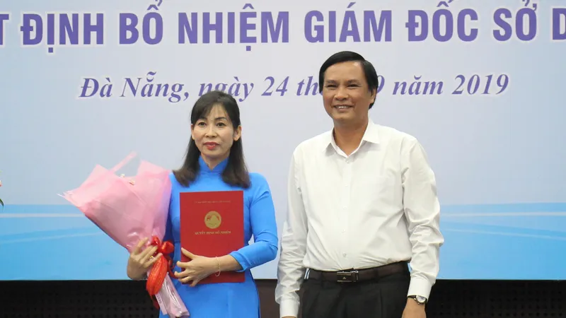 Ông Trần Văn Miên, Phó chủ tịch UBND TP Đà Nẵng trao quyết định và tặng hoa chúc mừng cho bà Trương Thị Hồng Hạnh