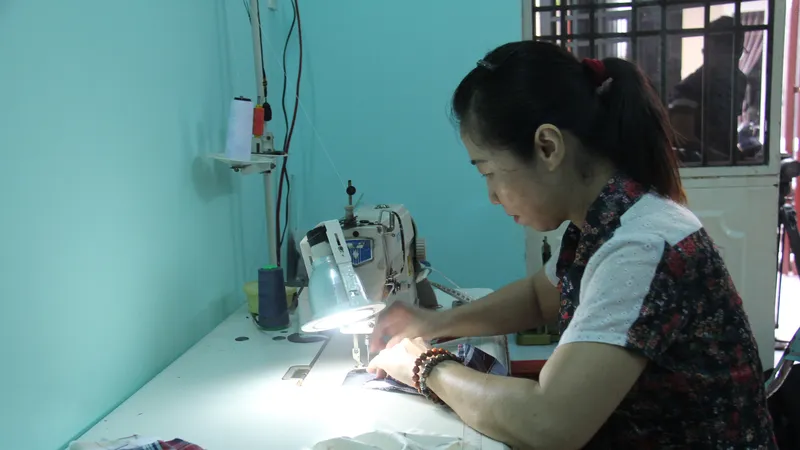 Bà Võ Thị Phương Lan đang miệt mài may những chiếc khẩu trang tại nhà