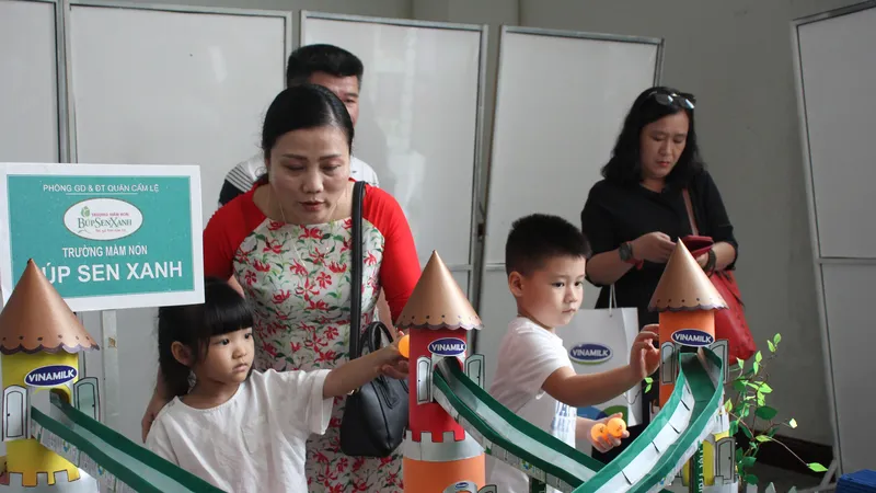 Các em học sinh mầm non xem mô hình đồ chơi làm từ vỏ hộp sữa