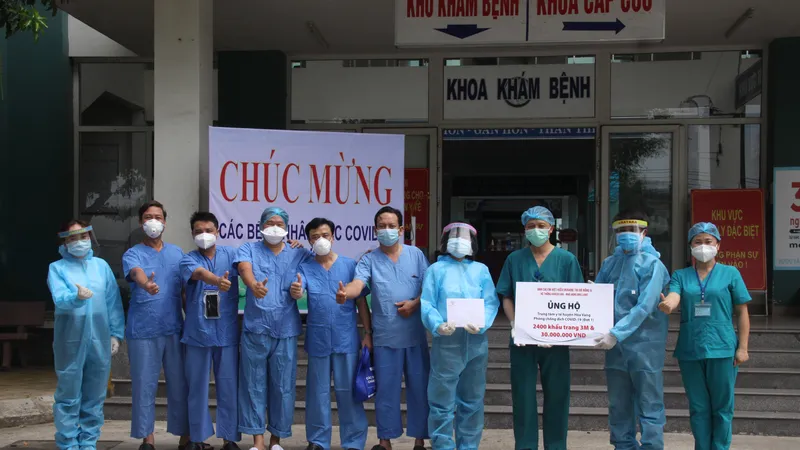 Bác sĩ Nguyễn Đại Vĩnh, Giám đốc Trung tâm Y tế Hòa Vang và đoàn bác sĩ Bệnh viện Chợ Rẫy chi viện cho BV dã chiến-TTYT Hòa Vang vui vẻ nhận quà 30 triệu đồng và 2.400 khẩu trang 3M do Báo Công an và nhà tài trợ trao tặng