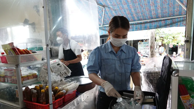 Chuyên viên An toàn thực phẩm- Ban quản lý các chợ quận Sơn Trà kiểm tra chất lượng thực phẩm tại một quầy hàng thuộc chợ Nại Hiên Đông