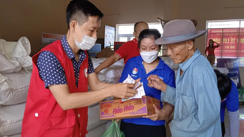 Nhân viên Hội Chữ thập đỏ hỗ trợ cấp phát nhu yếu phẩm cho người dân khó khăn