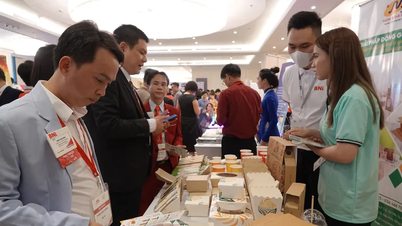 Các đại biểu tham quan một gian hàng làm sản phẩm bằng giấy, bảo vệ môi trường