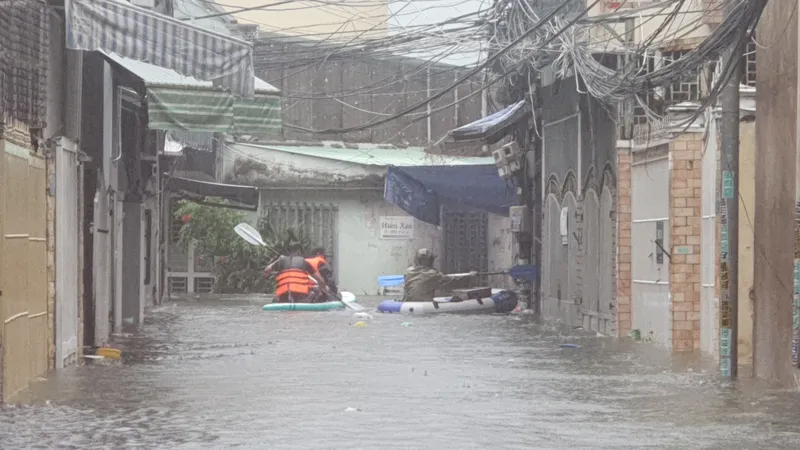 Lực lượng chức năng tiếp cận người dân khu ngập lụt bằng phao cứu sinh. Ảnh: XUÂN QUỲNH