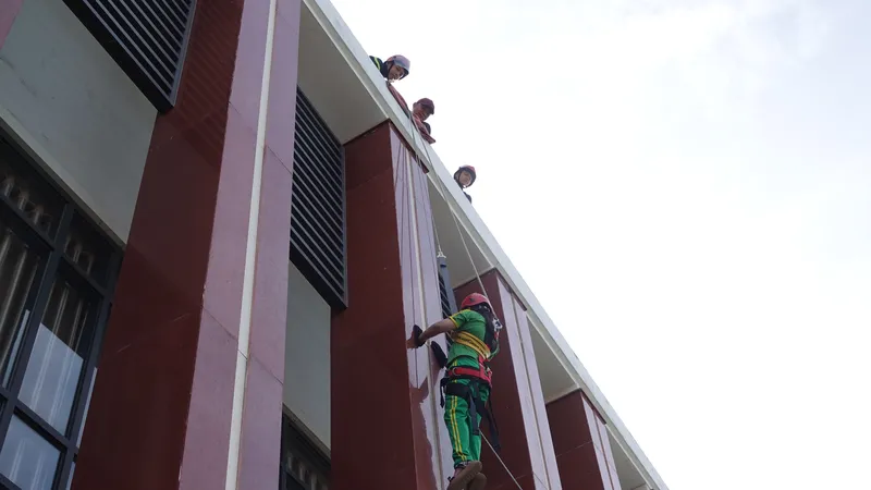 Các cô giáo lần lượt được tập luyện cách thoát hiểm khi ở tầng cao. Ảnh: XUÂN QUỲNH
