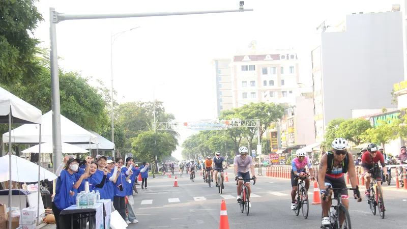 Các tình nguyện viên cổ vũ cho vận động viên tại phần thi đua xe đạp