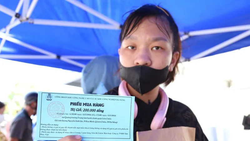 Mỗi thanh niên công nhân được Công đoàn Khu công nghệ cao và các khu công nghiệp Đà Nẵng phát phiếu mua hàng tại ngày hội. Ảnh: XUÂN QUỲNH