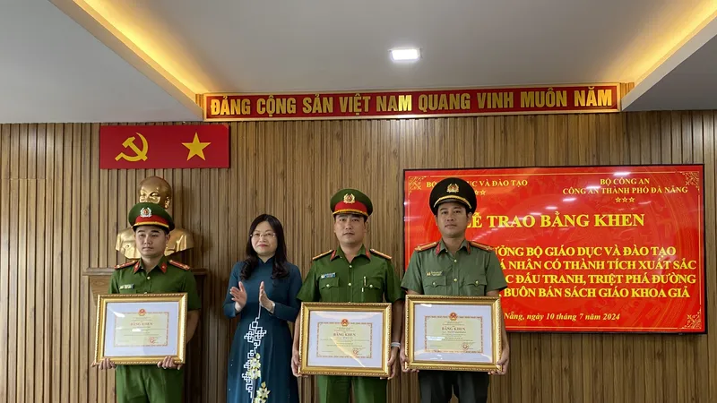 Thừa ủy quyền của Bộ trưởng Bộ GD-ĐT, bà Nguyễn Thị Hạnh trao Bằng khen cho 3 cá nhân. Ảnh: XUÂN QUỲNH