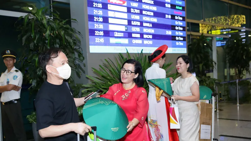 Nhân viên Trung tâm Xúc tiến Du lịch Đà Nẵng tặng quà lưu niệm cho du khách tại sân bay Đà Nẵng