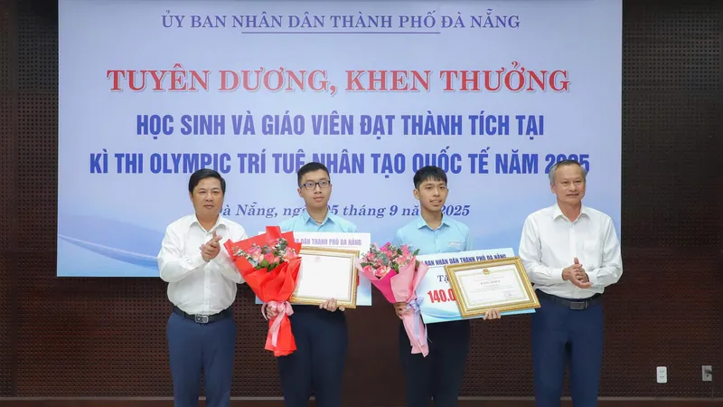 Ông Lương Nguyễn Minh Triết, Chủ tịch UBND TP Đà Nẵng và ông Đoàn Ngọc Hùng Anh, Phó Chủ tịch HĐND TP Đà Nẵng trao thưởng và tặng hoa chúc mừng 2 học sinh