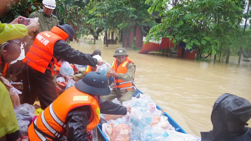 Cán bộ, chiến sĩ Vùng 3 Hải quân chuyển lương thực, nước uống xuống xuồng nhỏ để chuyển đến tay người dân