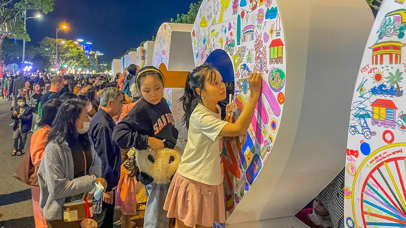 Đông đúc người dân, du khách tham gia sáng tạo trên bảng "Da Nang 2026". Ảnh: XUÂN QUỲNH